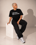Still Here. Still Covered. Unisex T-Shirt -Signature